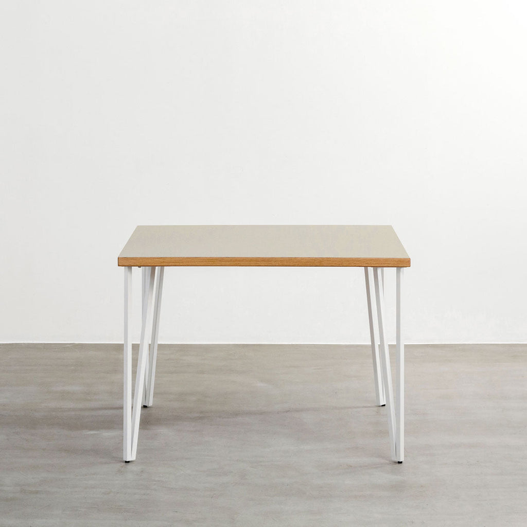 KANADEMONOのリノリウムPebble天板とトライアングルStraightホワイト脚4本を組み合わせた100cmスクエア型のカフェテーブル（正面）