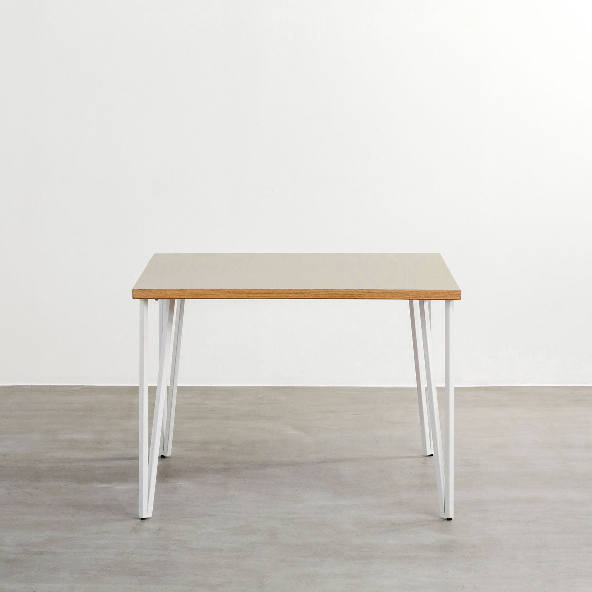 KANADEMONOのリノリウムPebble天板とトライアングルStraightホワイト脚4本を組み合わせた100cmスクエア型のカフェテーブル（正面）