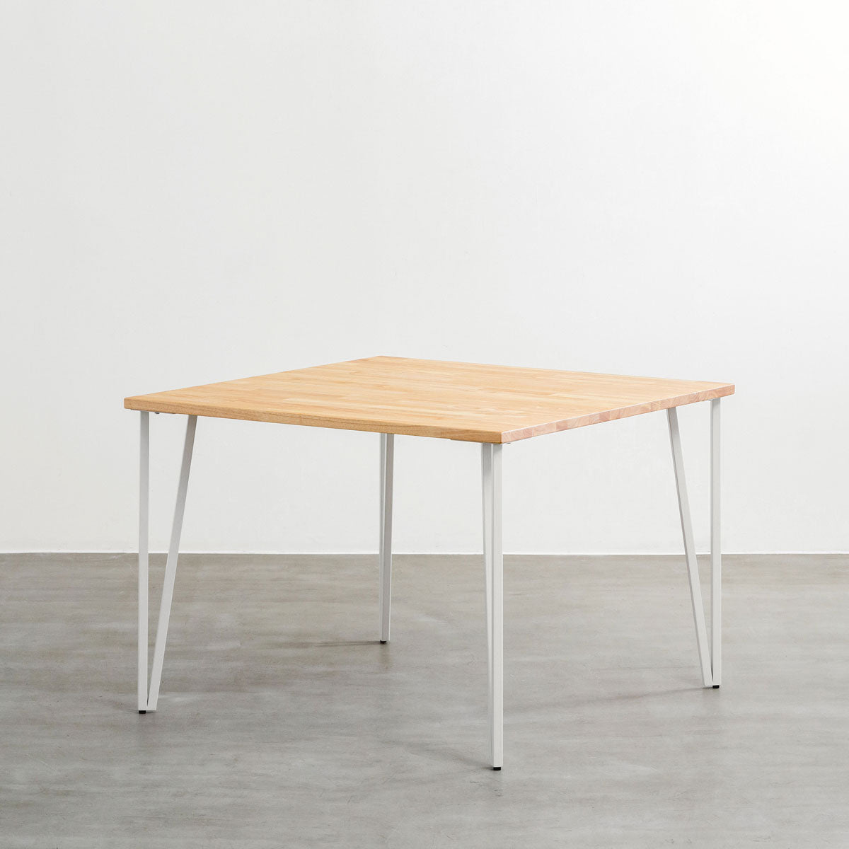 KANADEMONOのラバーウッドナチュラル天板とトライアングルStraightホワイト脚4本を組み合わせた100cmスクエア型のカフェテーブル（斜め）