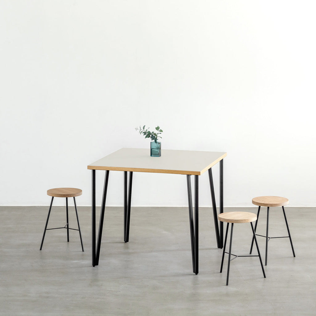 KANADEMONOのリノリウムMashroom天板とブラックトライアングルピン4本を組み合わせた一辺80cmスクエア型のカフェテーブル（使用例）