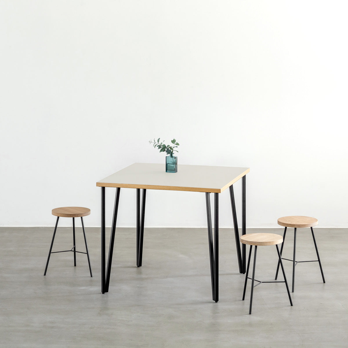 KANADEMONOのリノリウムMashroom天板とブラックトライアングルピン4本を組み合わせた一辺80cmスクエア型のカフェテーブル（使用例）