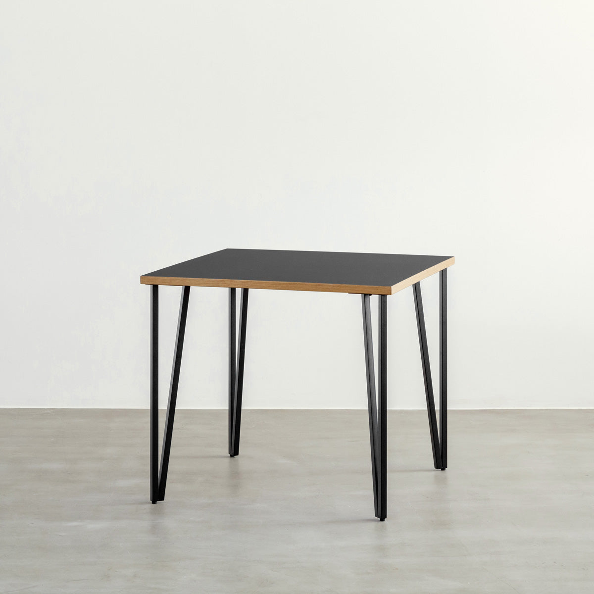KANADEMONOのリノリウムNero天板とブラックトライアングルピン4本を組み合わせた一辺80cmスクエア型のカフェテーブル