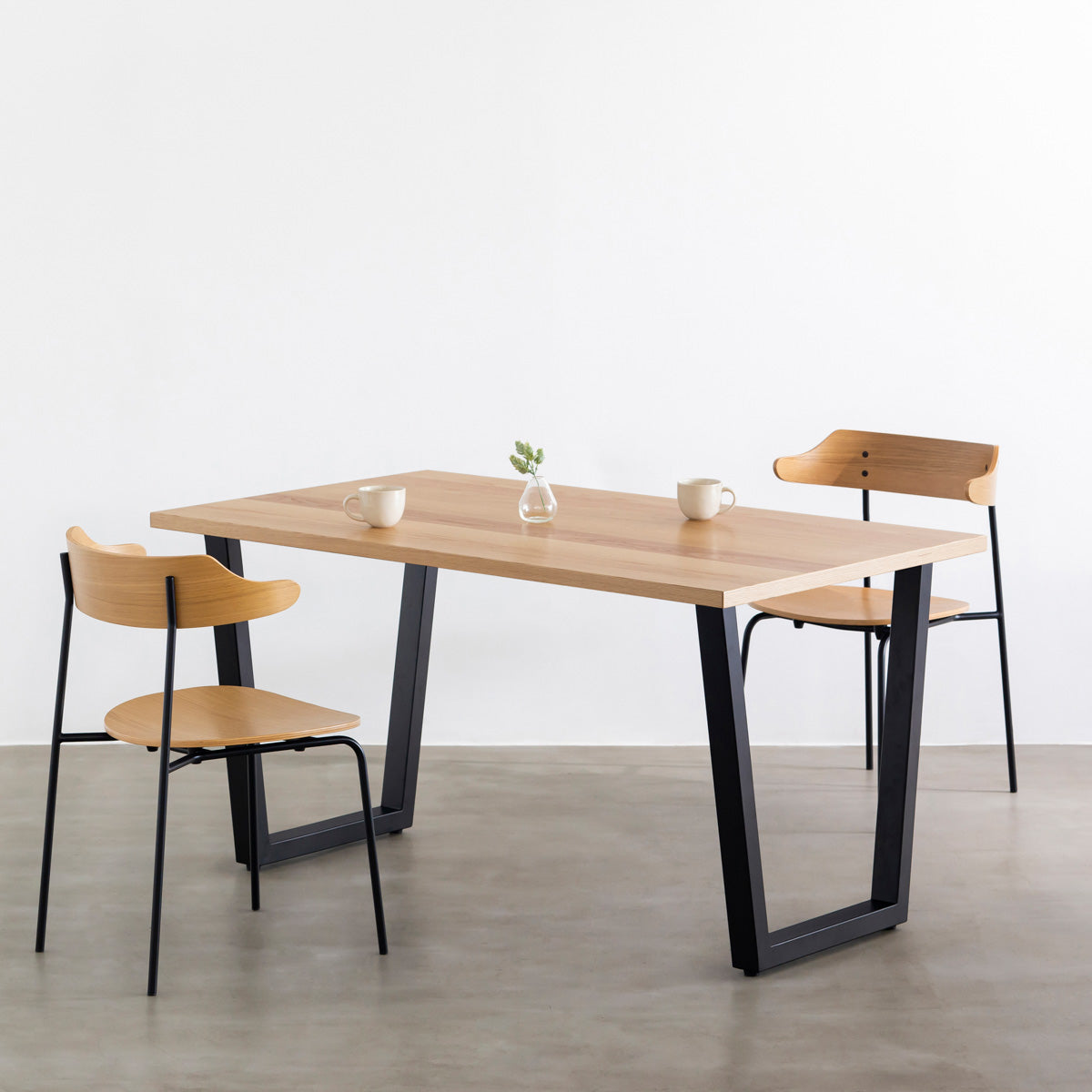 KANADEMONOのホワイトオーク突板天板とマットブラックのトラペゾイド鉄脚を組み合わせたシンプルモダンなテーブルの使用例1