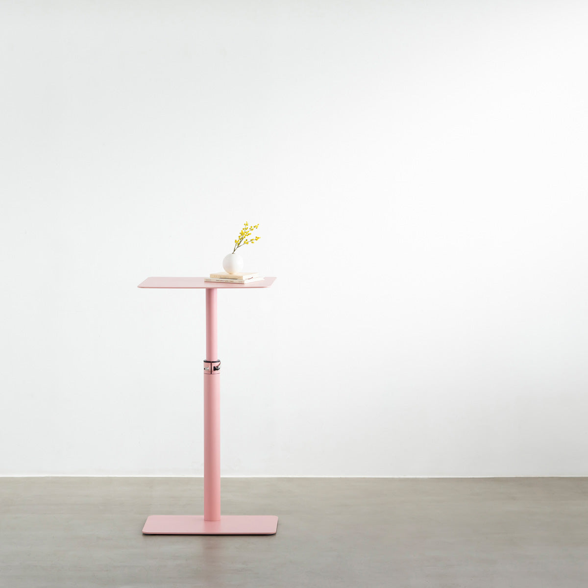 自由に高さを変えられる、シンプルでミニマルなライトピンク昇降サイドテーブルの使用例1