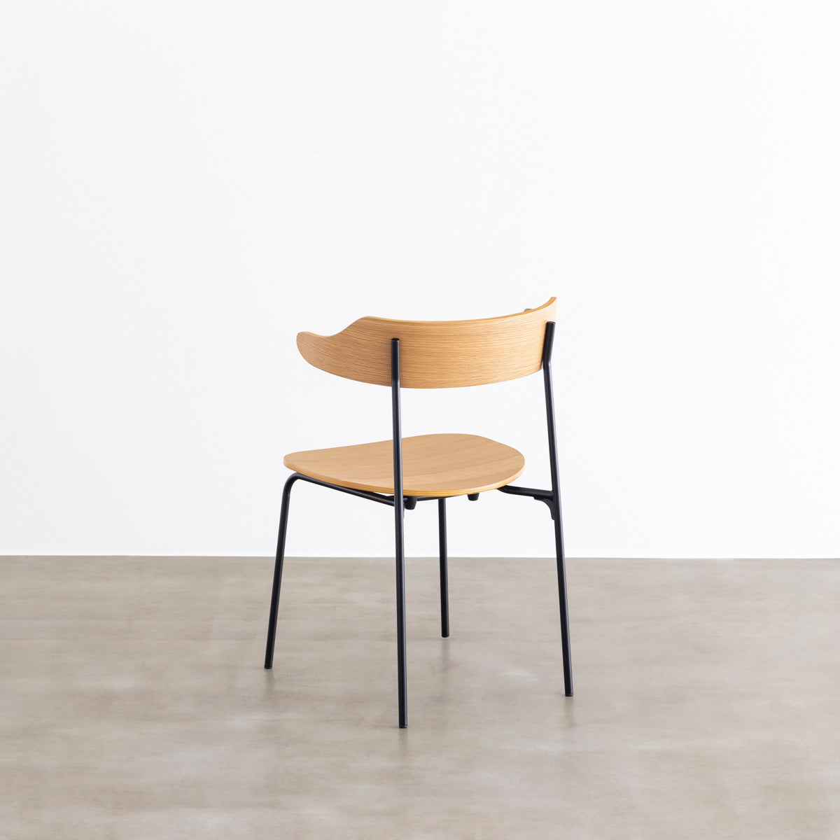 オーク材プライウッドとスチールを組み合わせたナチュラルカラーのハーフアームの板座ダイニングチェア（斜め後ろ）