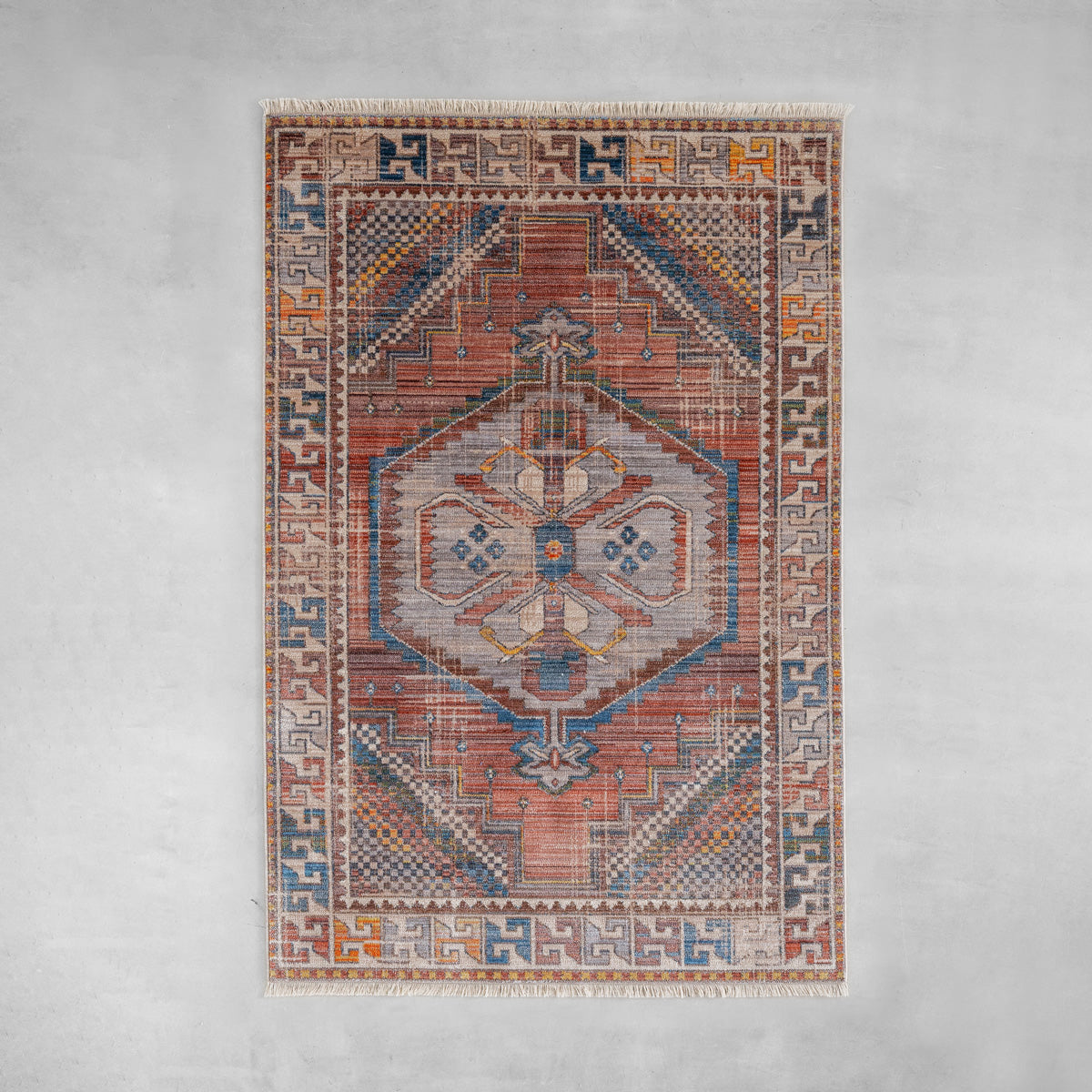 トライバルな要素と使い込まれたような趣ある暖色系のグラデーションが、温かな味わいを醸し出すオリエンタルデザインのラグ