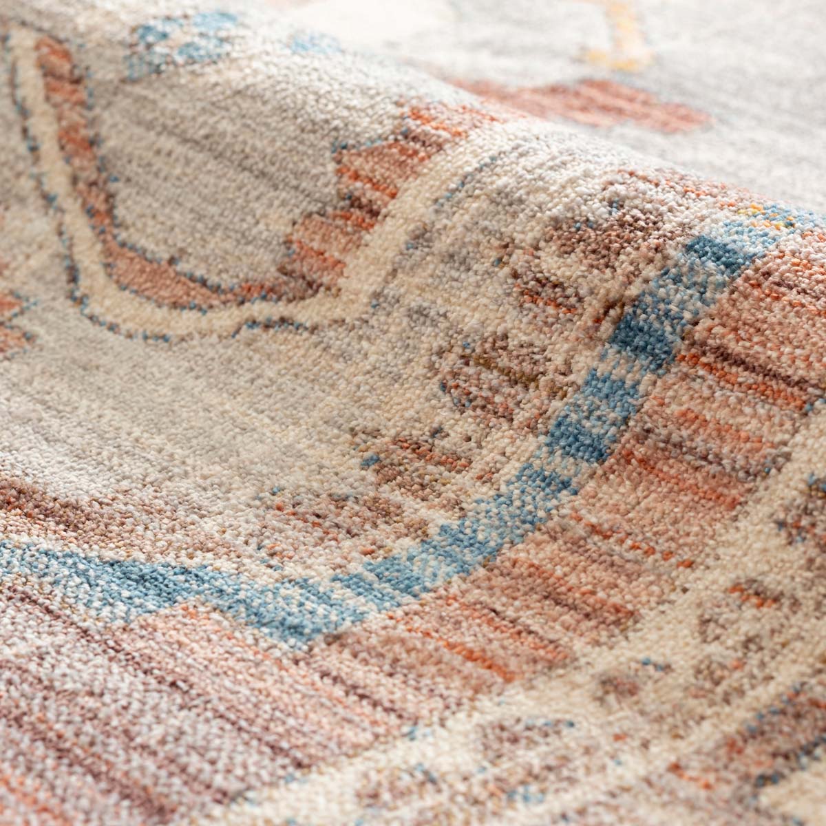 トライバルな要素と使い込まれたような趣ある暖色系のグラデーションが、温かな味わいを醸し出すオリエンタルデザインのラグの表面