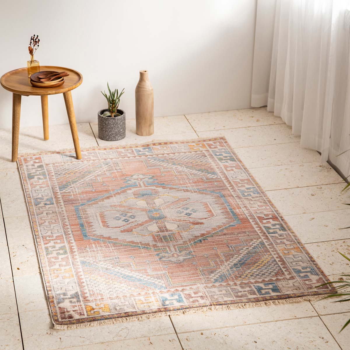 トライバルな要素と使い込まれたような趣ある暖色系のグラデーションが、温かな味わいを醸し出すオリエンタルデザインのラグの使用例1