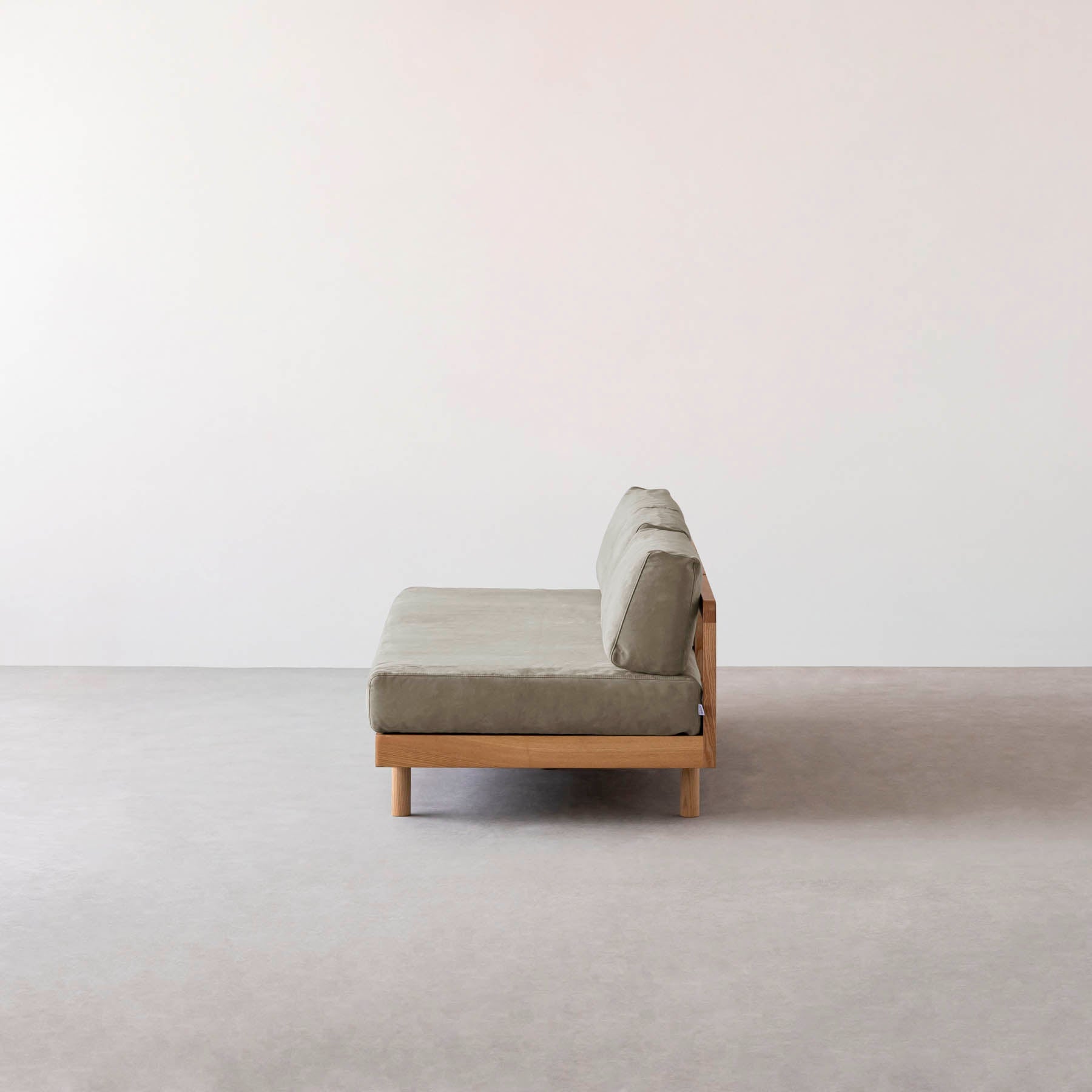 ライトグレーのファブリックにアッシュ無垢材を組み合わせたシンプルナチュラルなワイドタイプのソファ