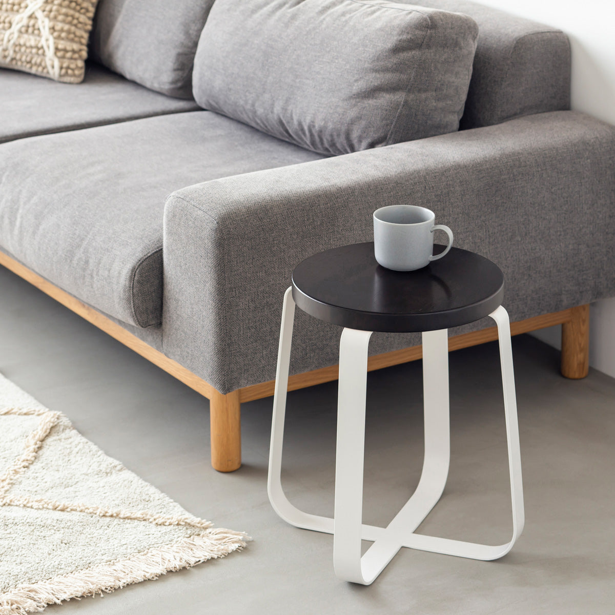 KANADEMONOのラバーウッド ブラックブラウンRound座面とホワイトのCross Plate脚を合わせたシンプルモダンなスツール（使用例2）