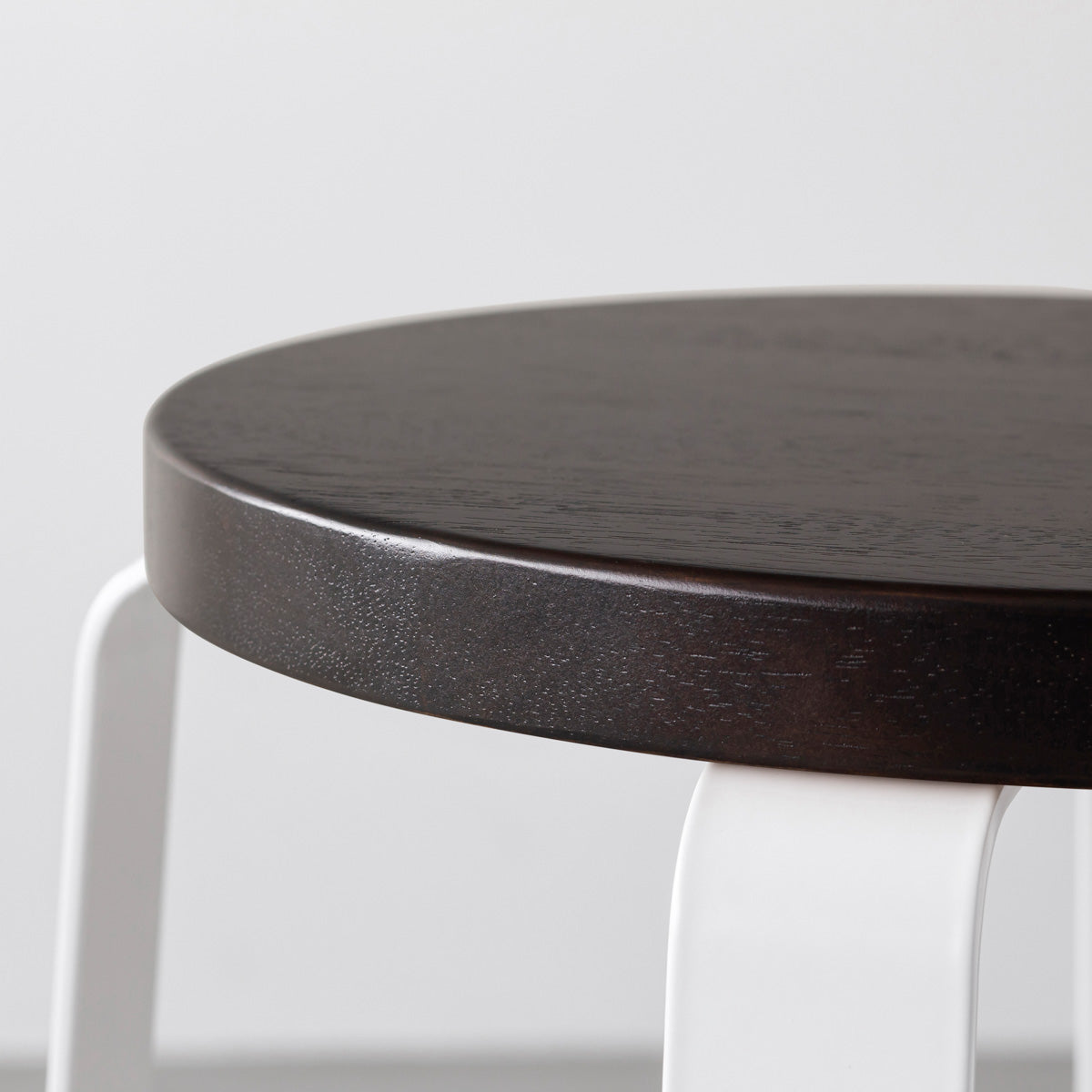 KANADEMONOのラバーウッド ブラックブラウンRound座面とホワイトのCross Plate脚を合わせたシンプルモダンなスツール（座面側面）