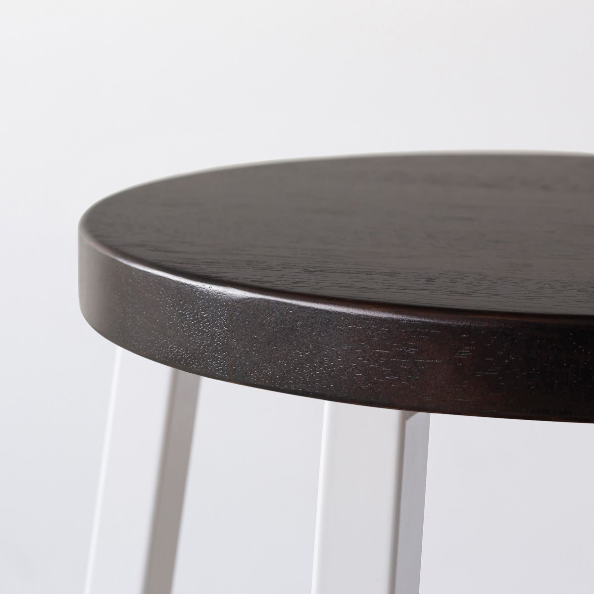 KANADEMONOのラバーウッド ブラックブラウンRound座面とホワイトのSlant Bar脚を合わせたシンプルモダンなスツール（座面側面）