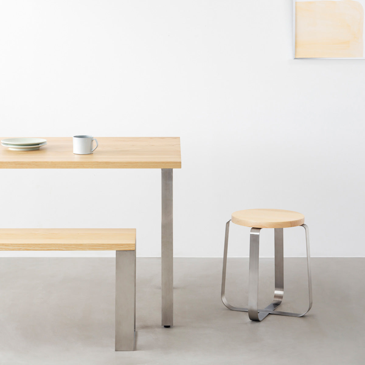 KANADEMONOの無垢ホワイトアッシュRound座面とステンレスのCross Plate脚を合わせたシンプルモダンなスツール（使用例）