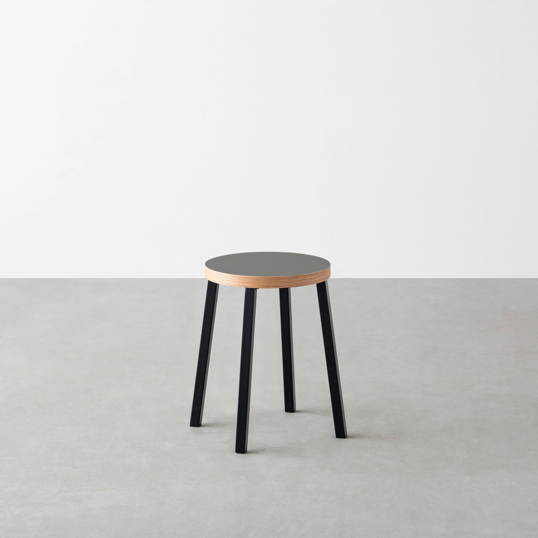 KanademonoのリノリウムPewter Round座面とブラックのSlant Bar脚を合わせたシンプルモダンなスツール