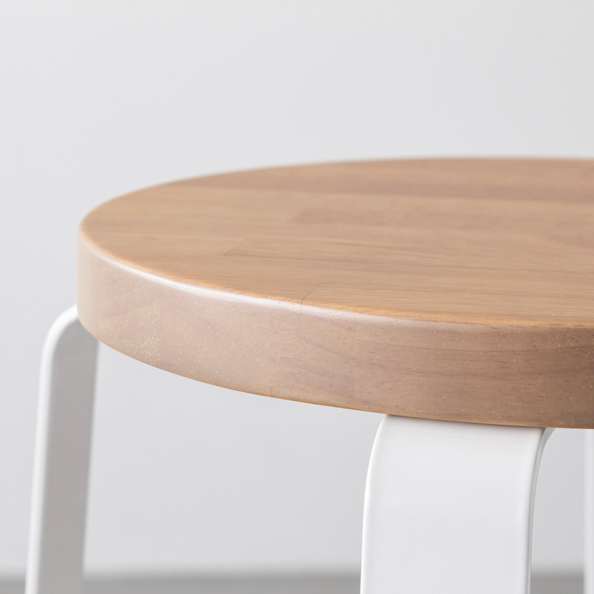 KANADEMONOのラバーウッド アッシュグレーRound座面とホワイトのCross Plate脚を合わせたシンプルモダンなスツール（座面側面）