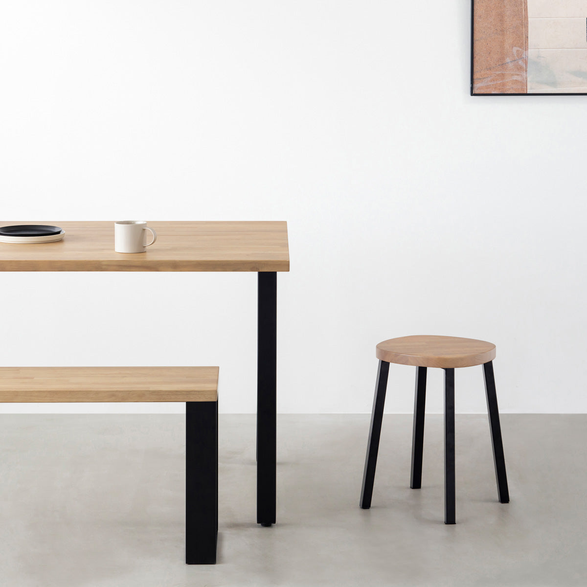 KANADEMONOのラバーウッド アッシュグレーSquircle座面とブラックのSlant Bar脚を合わせたシンプルモダンなスツール（使用例）