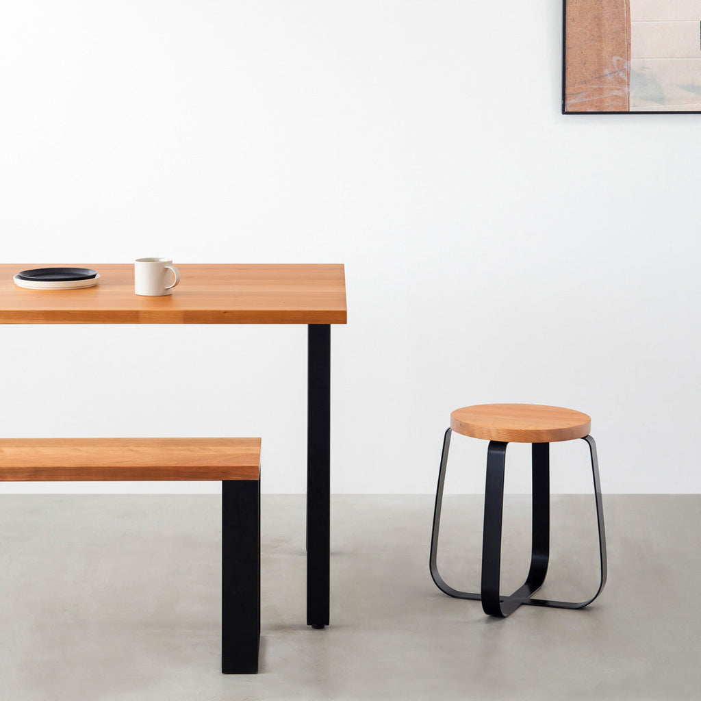 KANADEMONOの無垢ブラックチェリーRound座面とブラックのCross Plate脚を合わせたシンプルモダンなスツール（使用例）