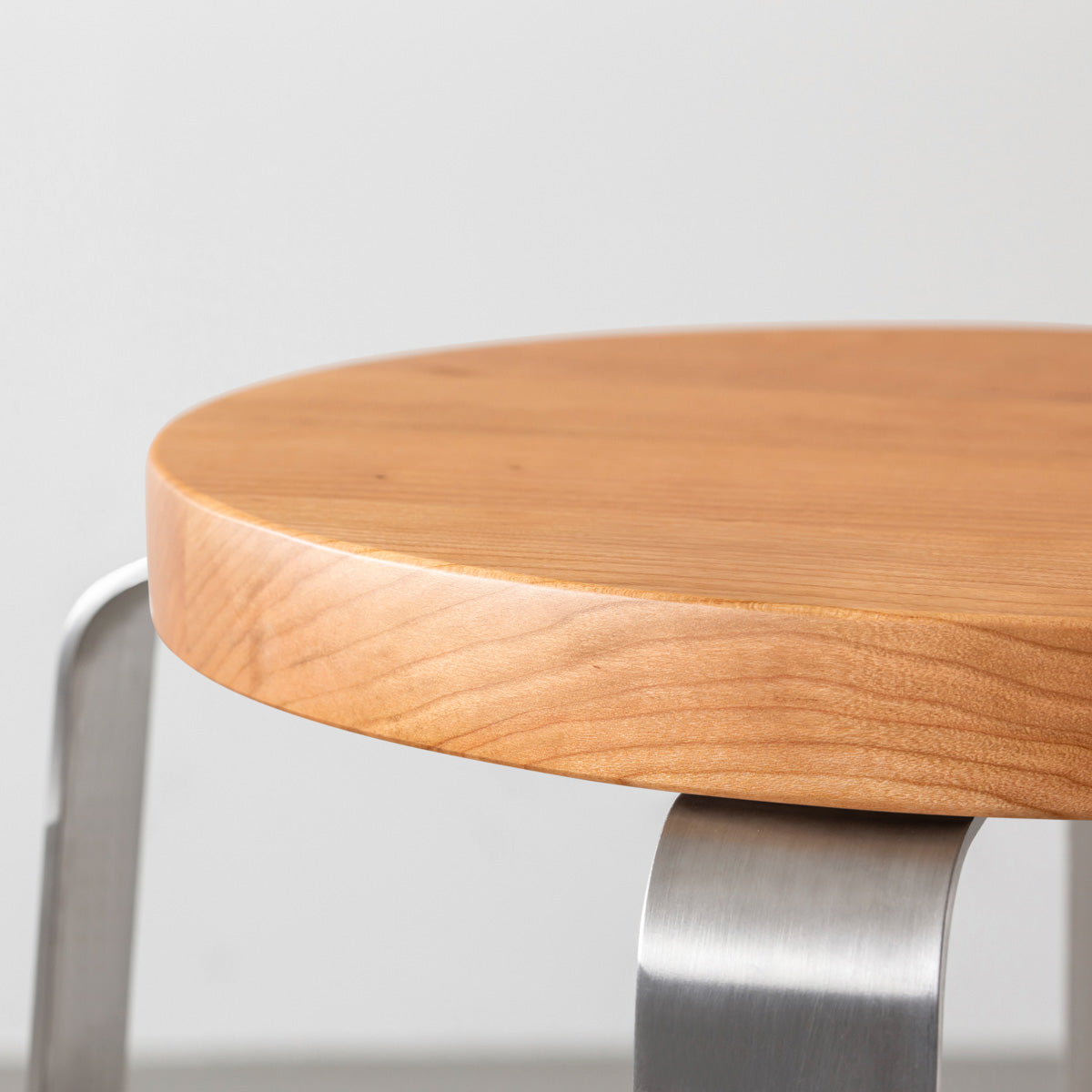 KANADEMONOの無垢ブラックチェリーRound座面とステンレスのCross Plate脚を合わせたシンプルモダンなスツール （座面側面）