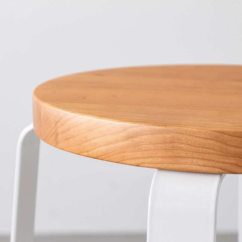 KANADEMONOの無垢ブラックチェリーRound座面とホワイトのCross Plate脚を合わせたシンプルモダンなスツール（座面側面）