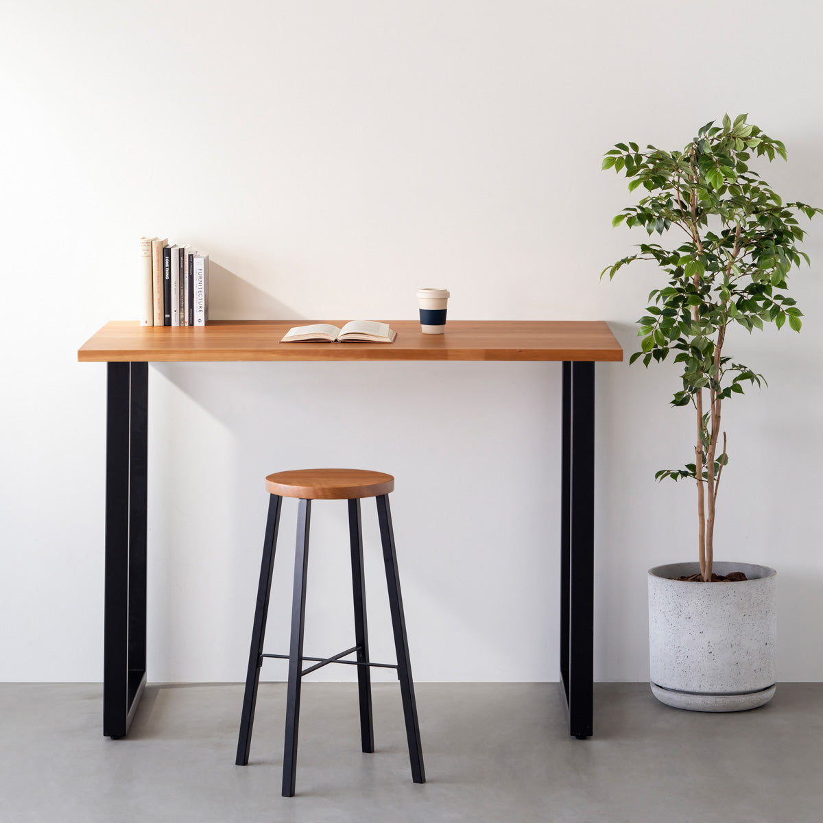 KANADEMONOの無垢ブラックチェリーRound座面とブラックのSlant Bar脚を合わせたシンプルモダンなハイスツール（使用例）