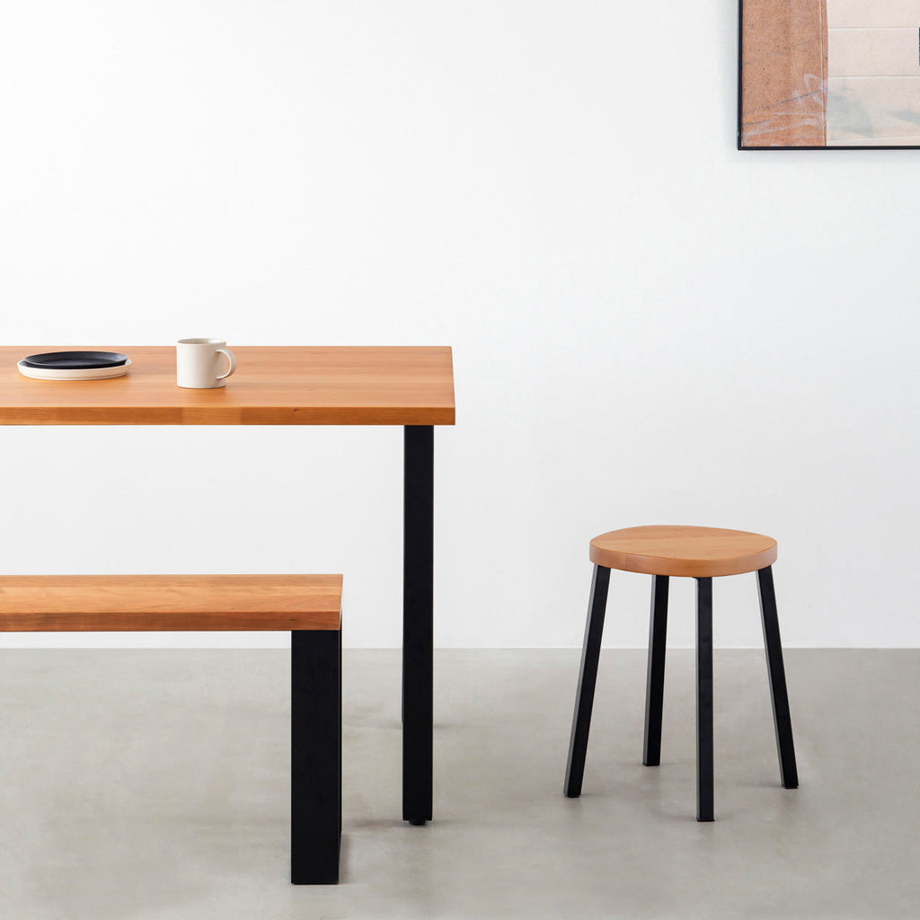 KANADEMONOの無垢ブラックチェリーSquircle座面とブラックのSlant Bar脚を合わせたシンプルモダンなスツール（使用例）