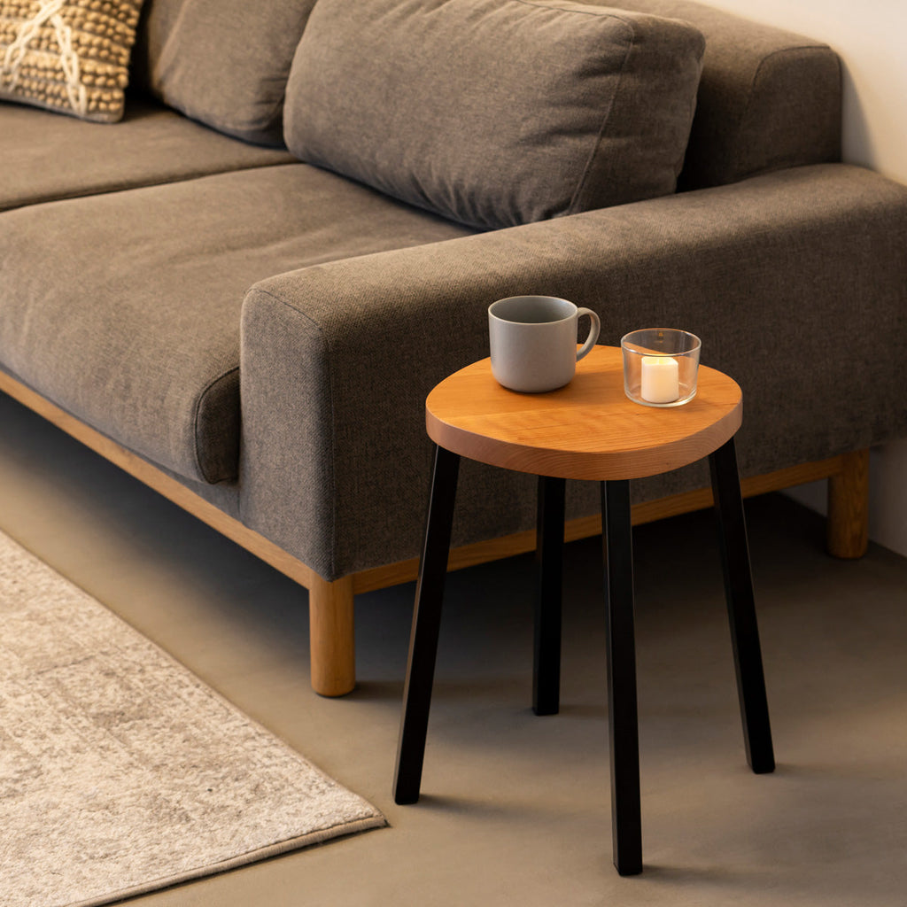 KANADEMONOの無垢ブラックチェリーSquircle座面とブラックのSlant Bar脚を合わせたシンプルモダンなスツール（使用例2）