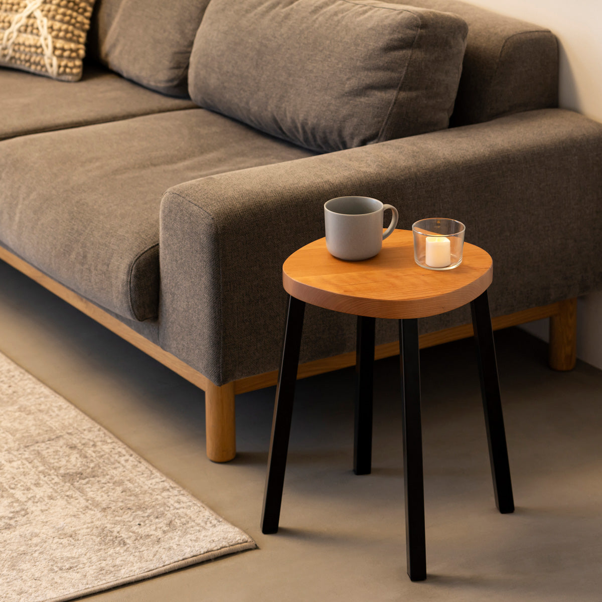 KANADEMONOの無垢ブラックチェリーSquircle座面とブラックのSlant Bar脚を合わせたシンプルモダンなスツール（使用例2）