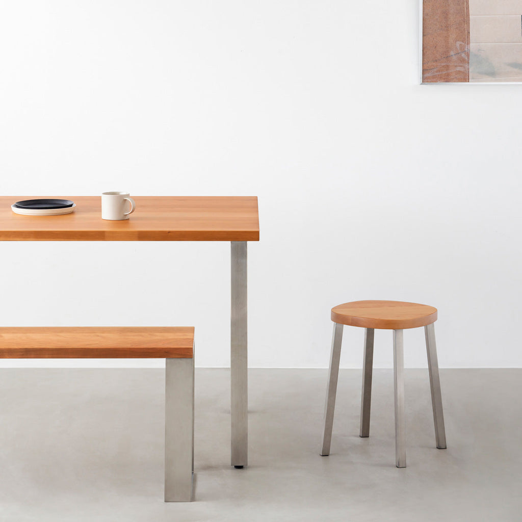 KANADEMONOの無垢ブラックチェリーSquircle座面とステンレスのSlant Bar脚を合わせたシンプルモダンなスツール（使用例）