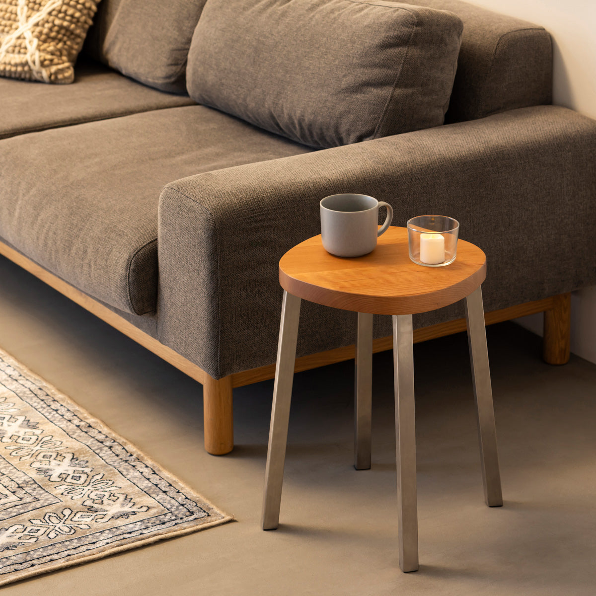 KANADEMONOの無垢ブラックチェリーSquircle座面とステンレスのSlant Bar脚を合わせたシンプルモダンなスツール（使用例2）