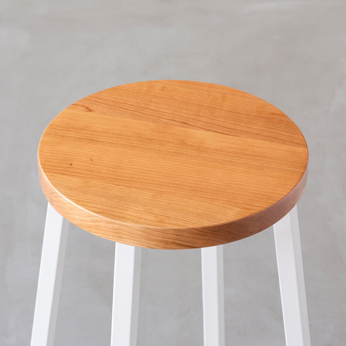 KANADEMONOの無垢ブラックチェリーRound座面とホワイトのSlant Bar脚を合わせたシンプルモダンなスツール（座面）