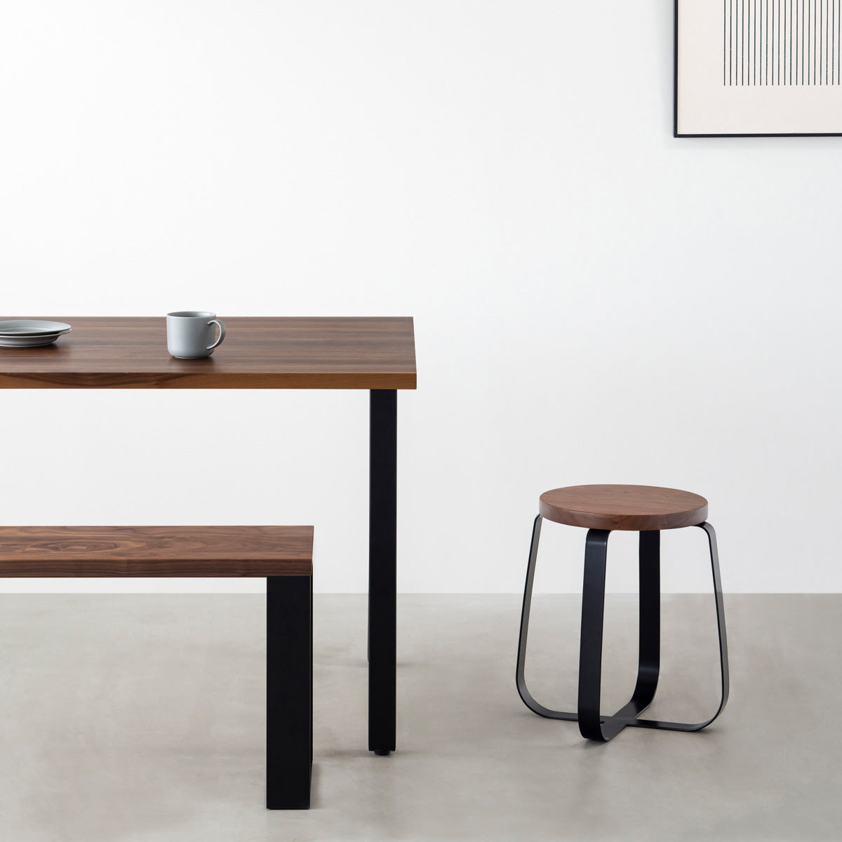 KANADEMONOの無垢ウォルナットRound座面とブラックのCross Plate脚を合わせたシンプルモダンなスツール（使用例）