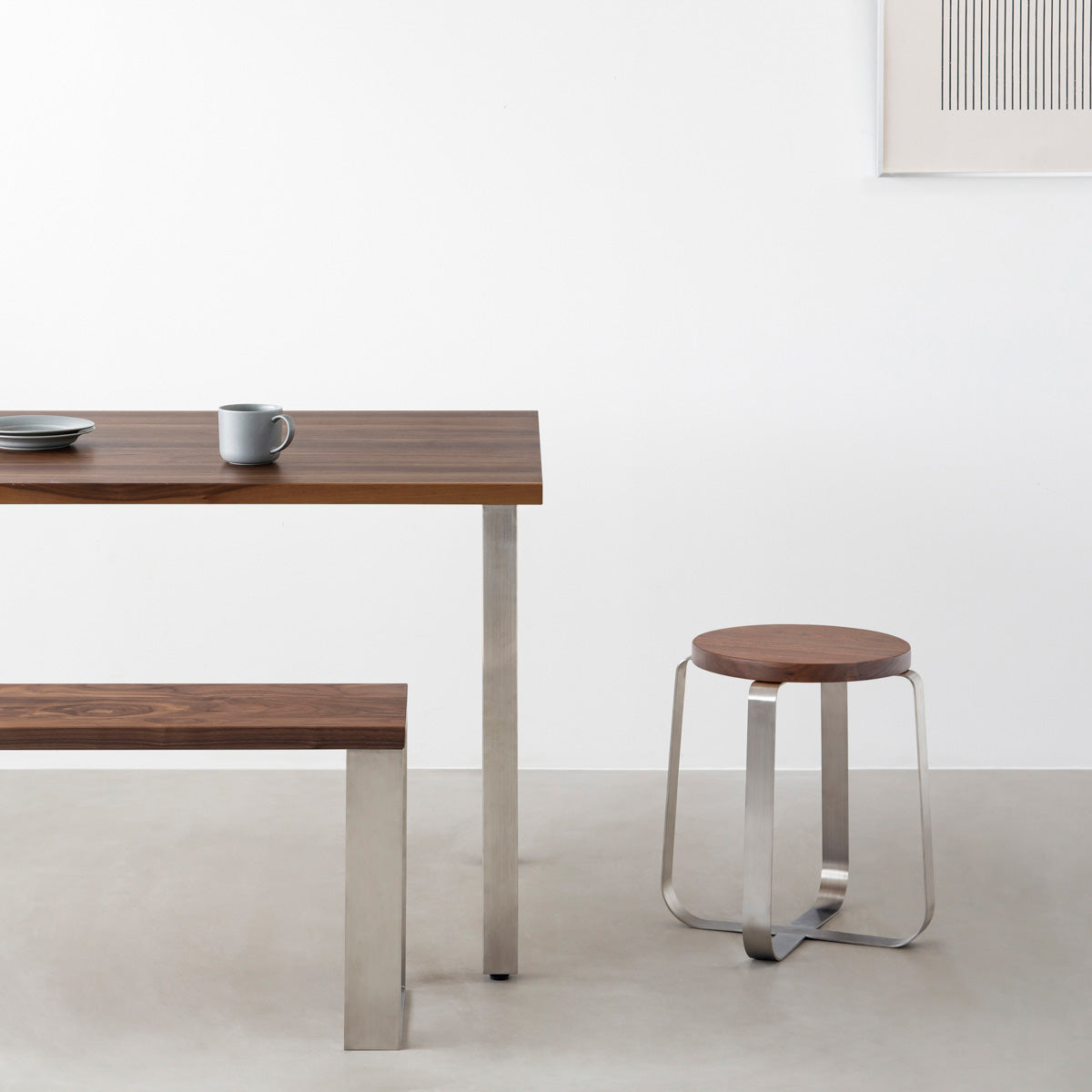 KANADEMONOの無垢ウォルナットRound座面とステンレスのCross Plate脚を合わせたシンプルモダンなスツール（使用例）