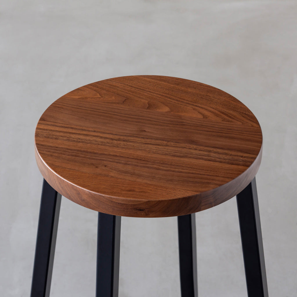 KANADEMONOの無垢ウォルナットRound座面とブラックのSlant Bar脚を合わせたシンプルモダンなハイスツール（座面）