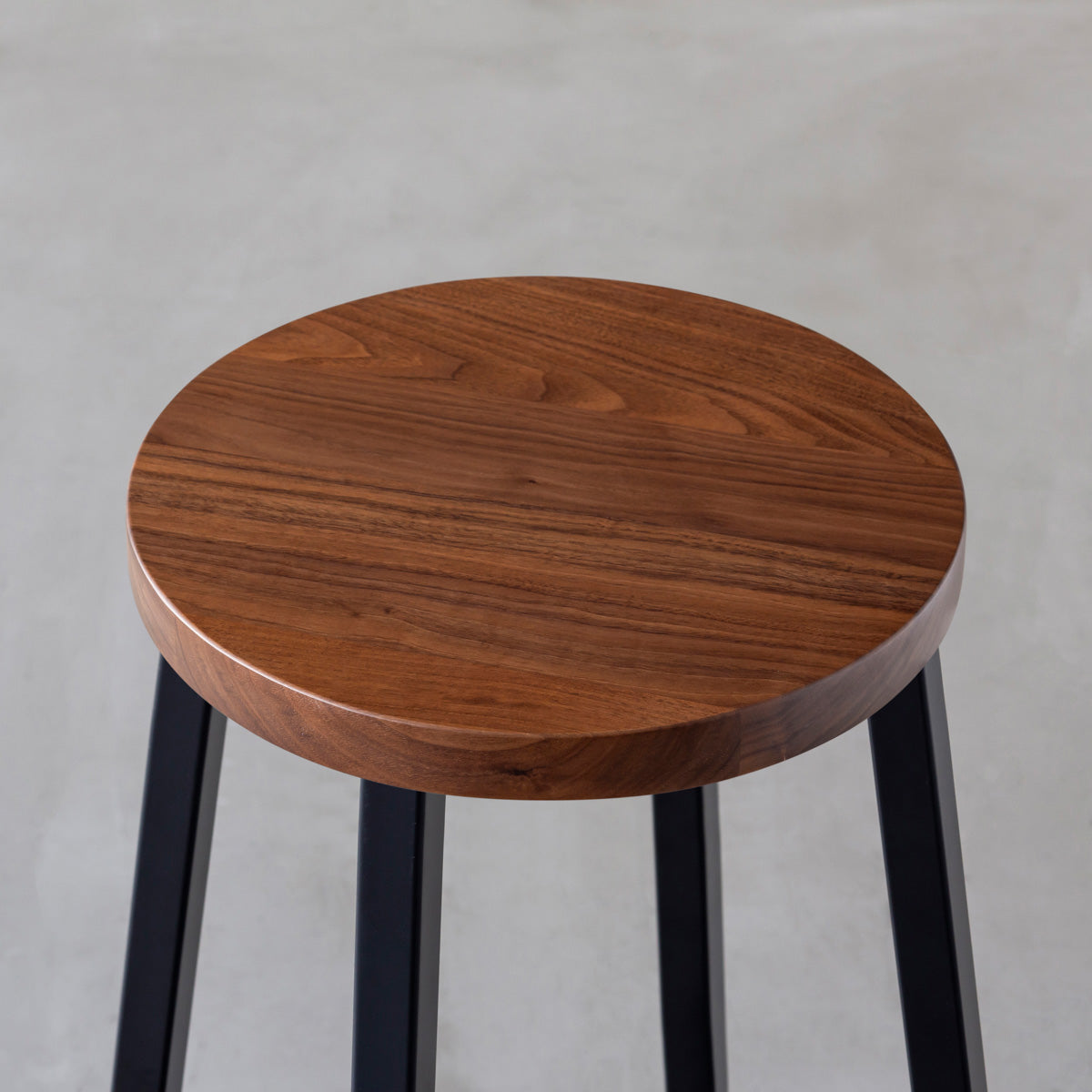 KANADEMONOの無垢ウォルナットRound座面とブラックのSlant Bar脚を合わせたシンプルモダンなハイスツール（座面）