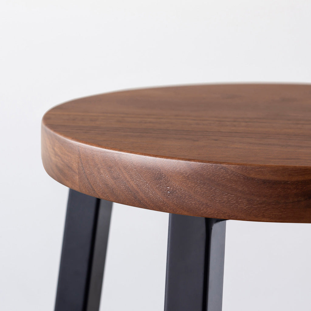 KANADEMONOの無垢ウォルナットRound座面とブラックのSlant Bar脚を合わせたシンプルモダンなスツール（座面側面）