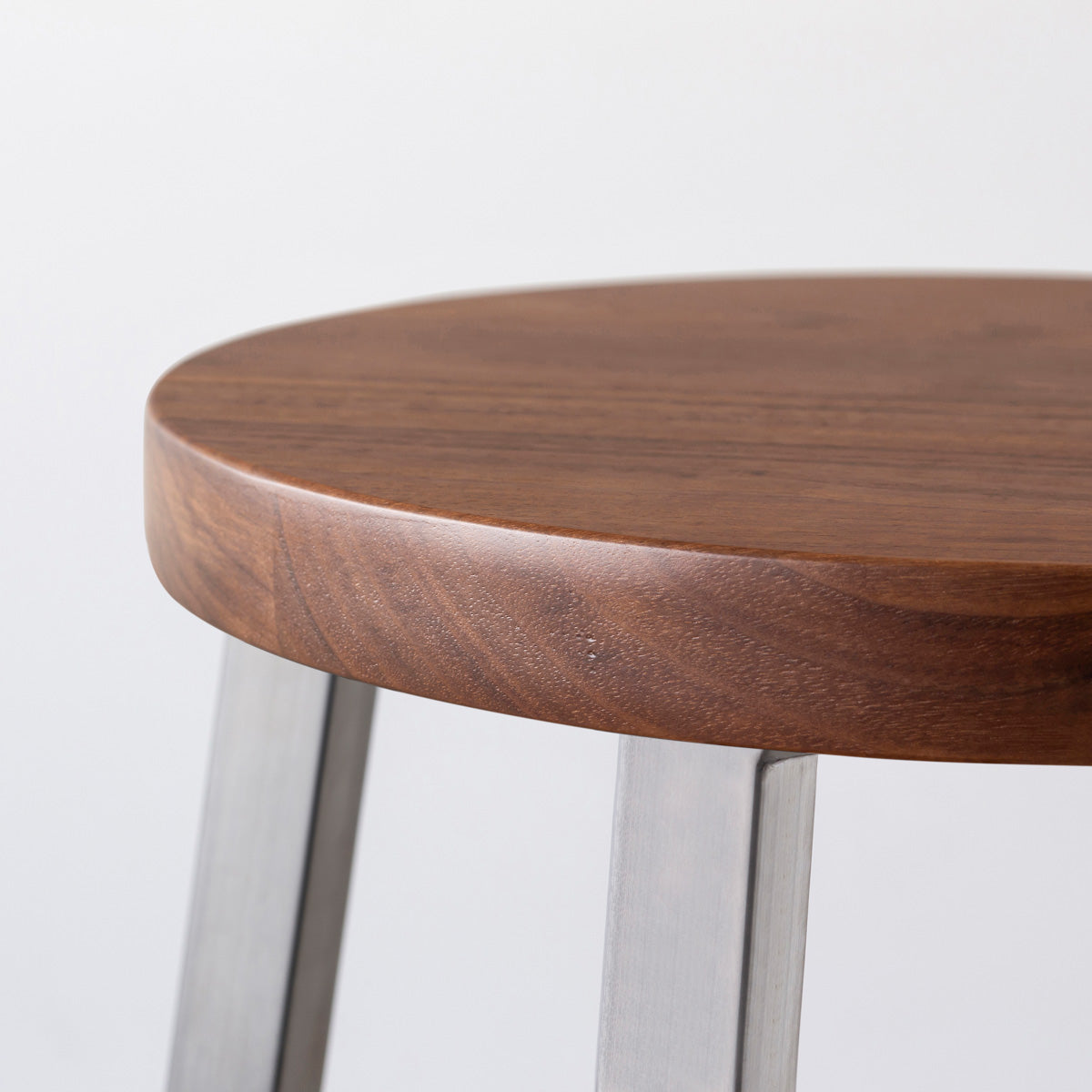 KANADEMONOの無垢ウォルナットRound座面とステンレスのSlant Bar脚を合わせたシンプルモダンなハイスツール（座面側面）
