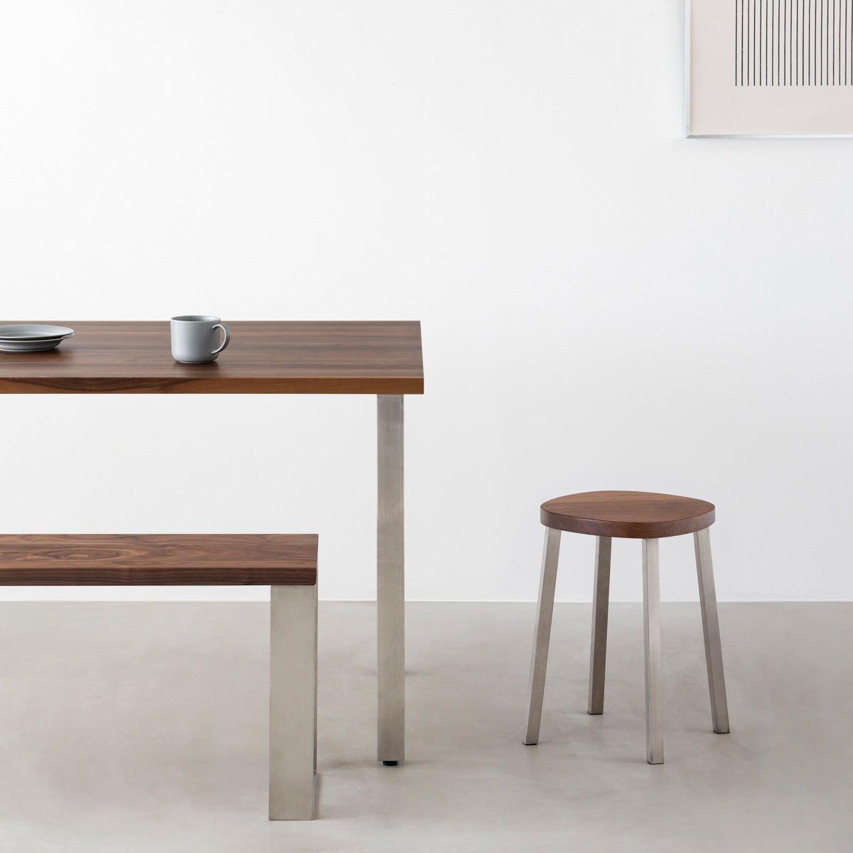 KANADEMONOの無垢ウォルナットSquircle座面とステンレスのSlant Bar脚を合わせたシンプルモダンなスツール（使用例）