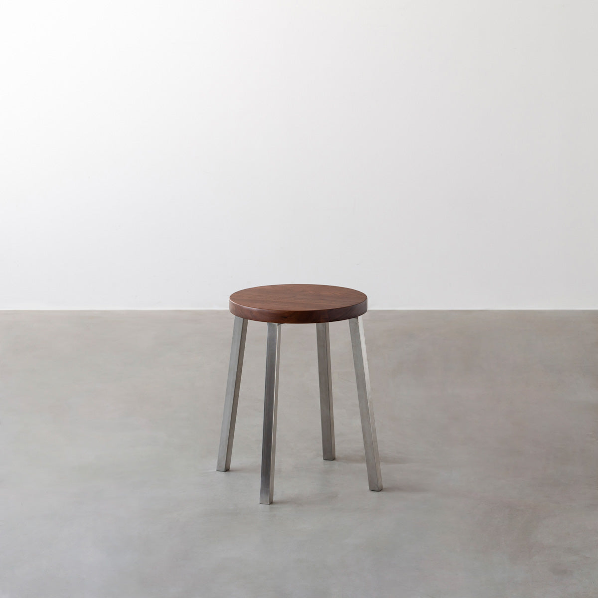 KANADEMONOの無垢ウォルナットRound座面とステンレスのSlant Bar脚を合わせたシンプルモダンなスツール