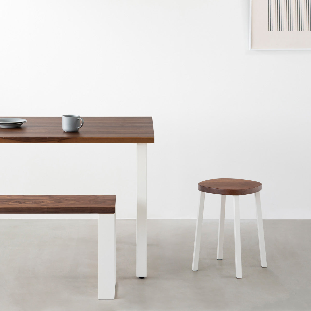 KANADEMONOの無垢ウォルナットSquircle座面とホワイトのSlant Bar脚を合わせたシンプルモダンなスツール（使用例）