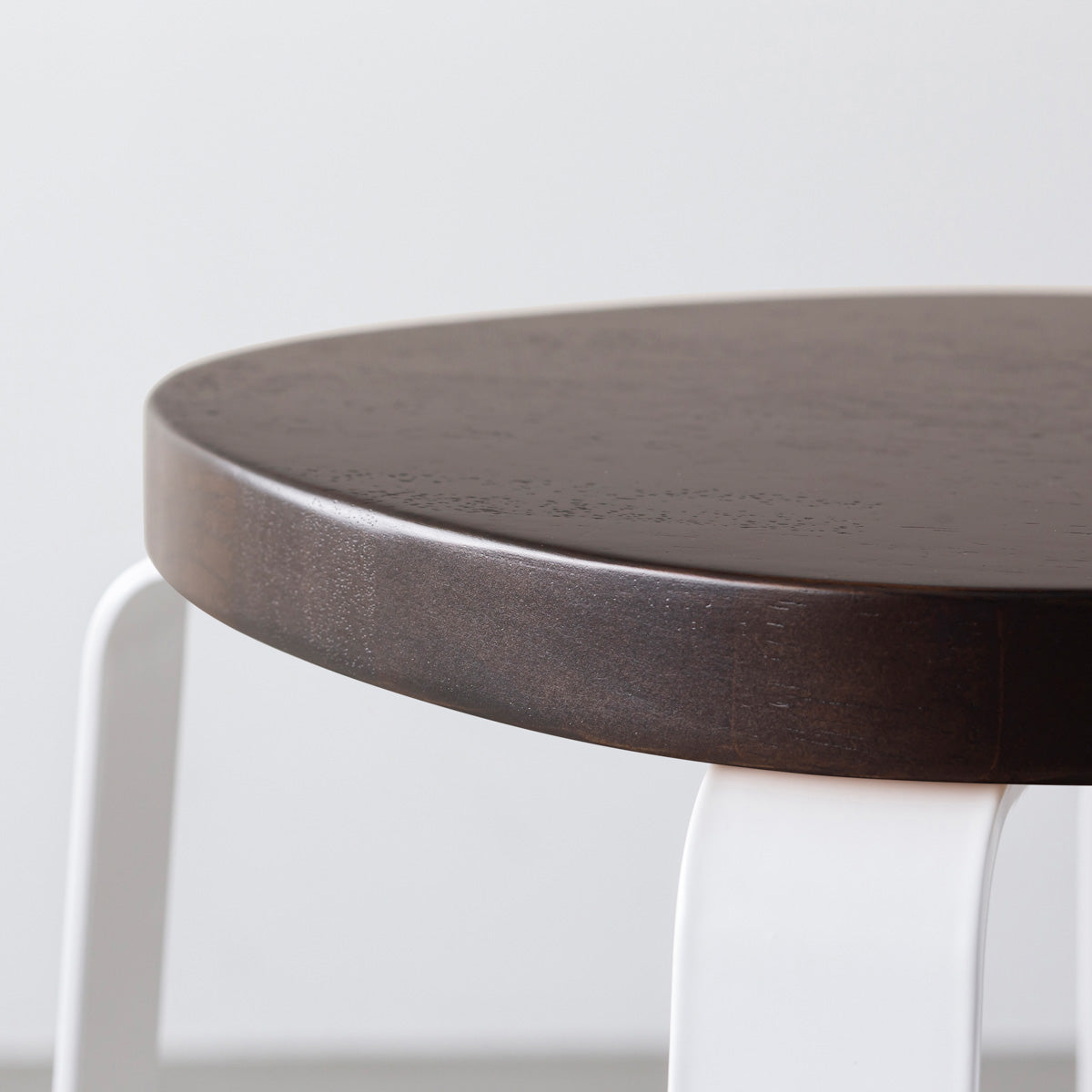 KANADEMONOのラバーウッド ブラックブラウンSquircle座面とホワイトのCross Plate脚を合わせたシンプルモダンなスツール（座面側面）