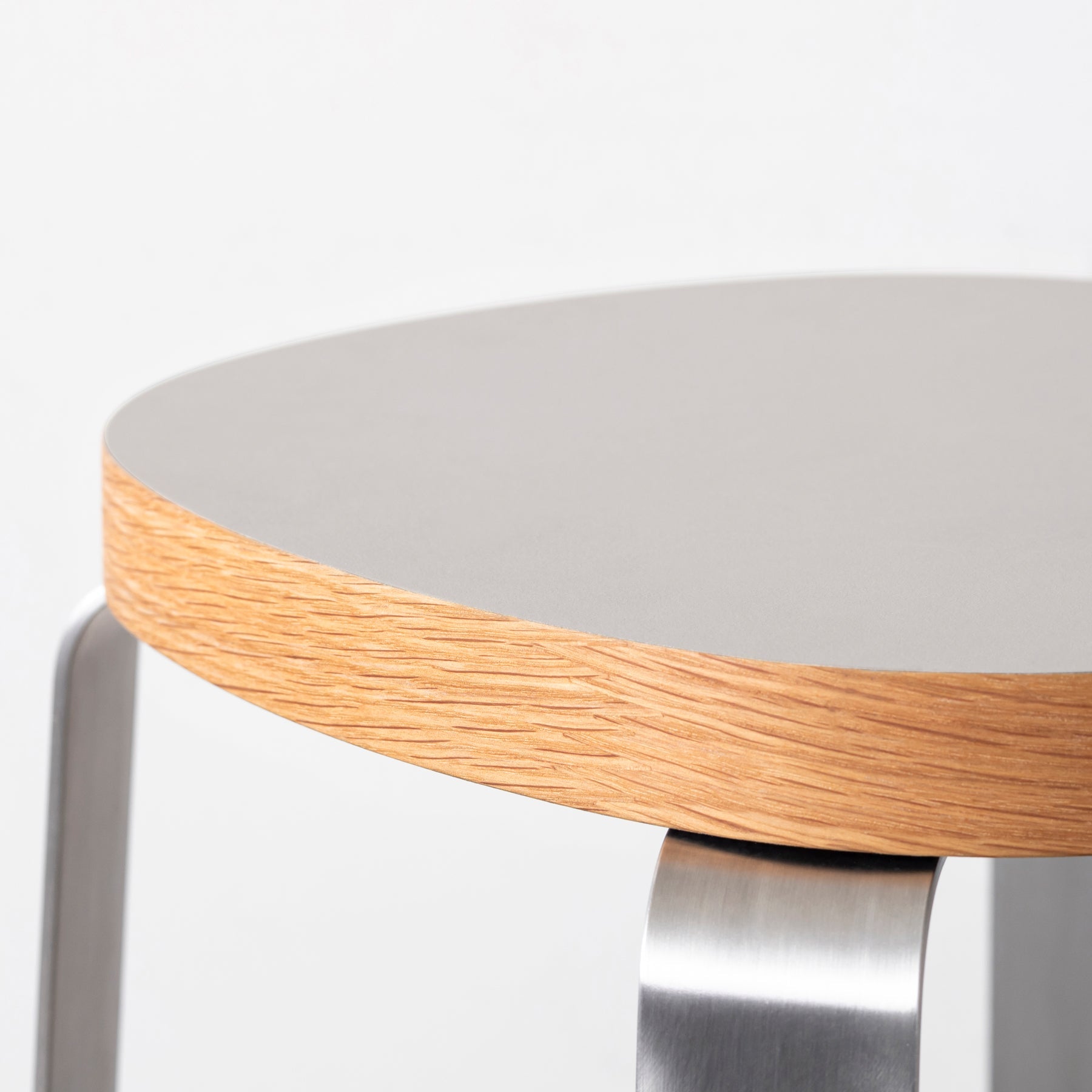 KanademonoのリノリウムPebble Squircle座面とステンレスのCross_Plate脚を合わせたシンプルモダンなHighスツール（座面側面）