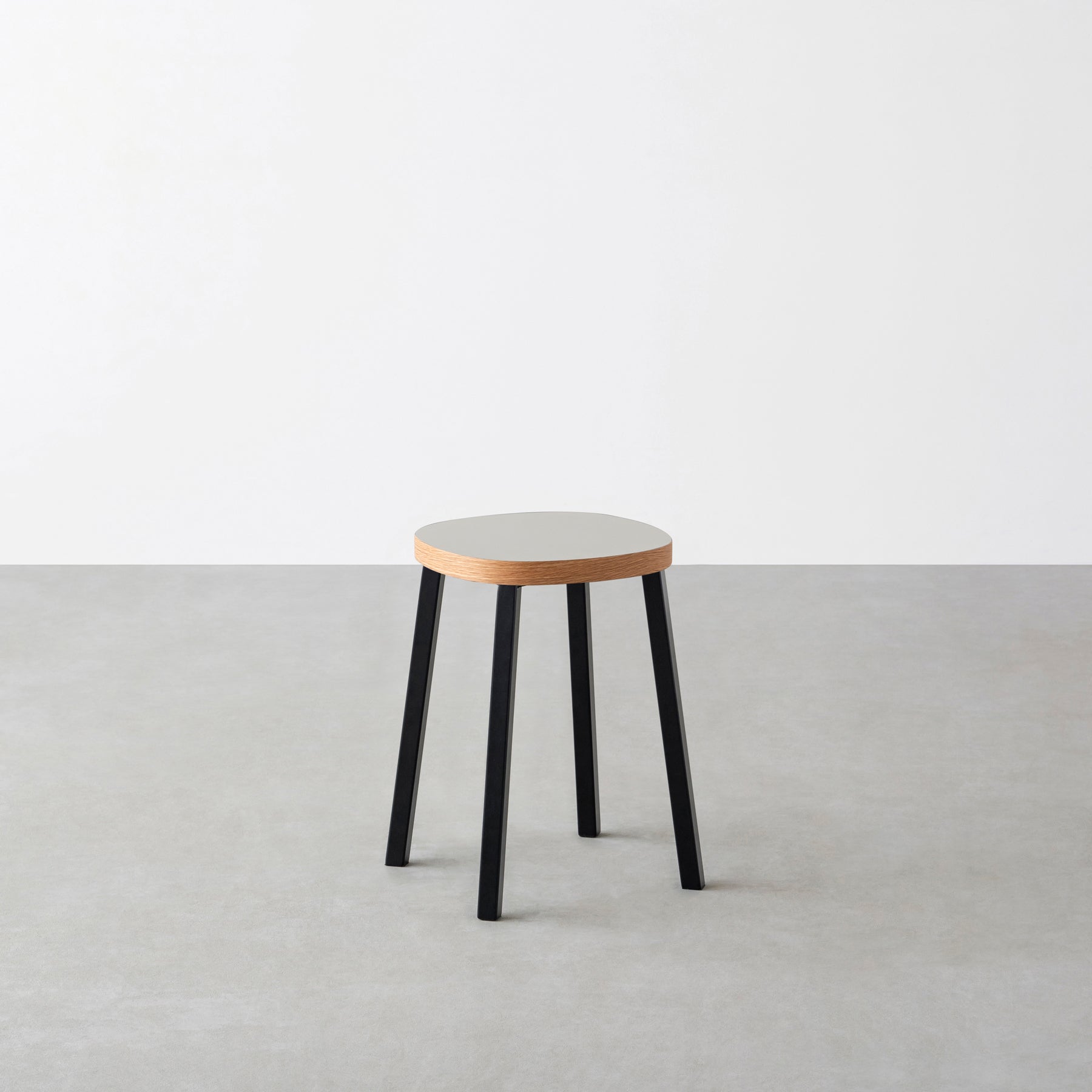KanademonoのリノリウムPebble Squircle座面とブラックのSlant Bar脚を合わせたシンプルモダンなスツール