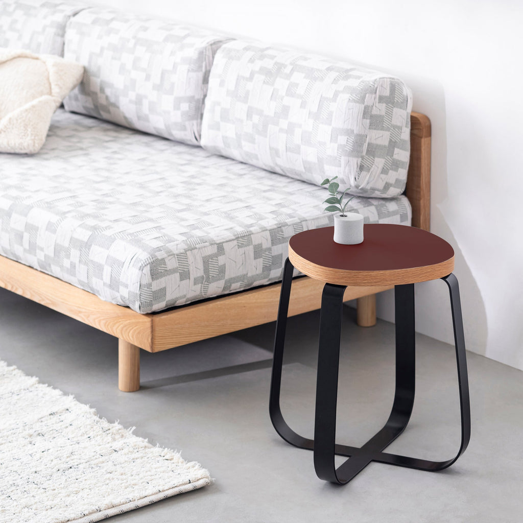 KanademonoのリノリウムBurgundy Squircle座面とブラックのCross Plate脚を合わせたシンプルモダンなスツール（使用例）