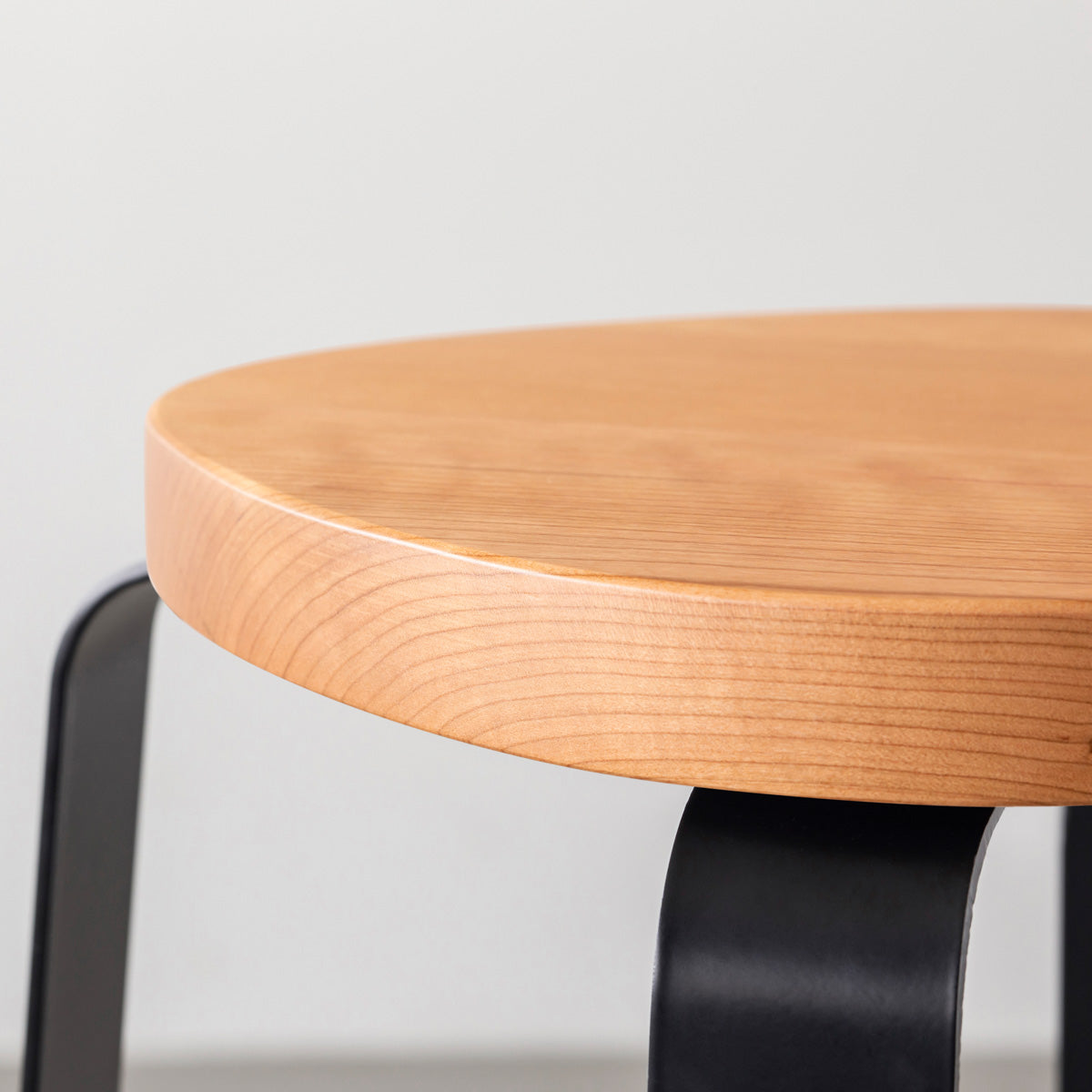 KANADEMONOの無垢ブラックチェリーSquircle座面とブラックのCross Plate脚を合わせたシンプルモダンなスツール（座面側面）