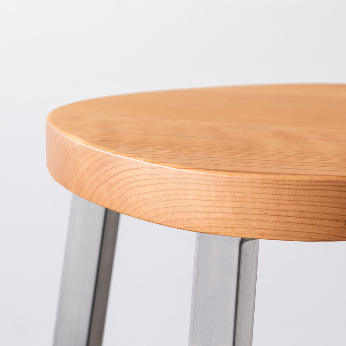 KANADEMONOの無垢ブラックチェリーSquircle座面とステンレスのSlant Bar脚を合わせたシンプルモダンなスツール（座面側面）