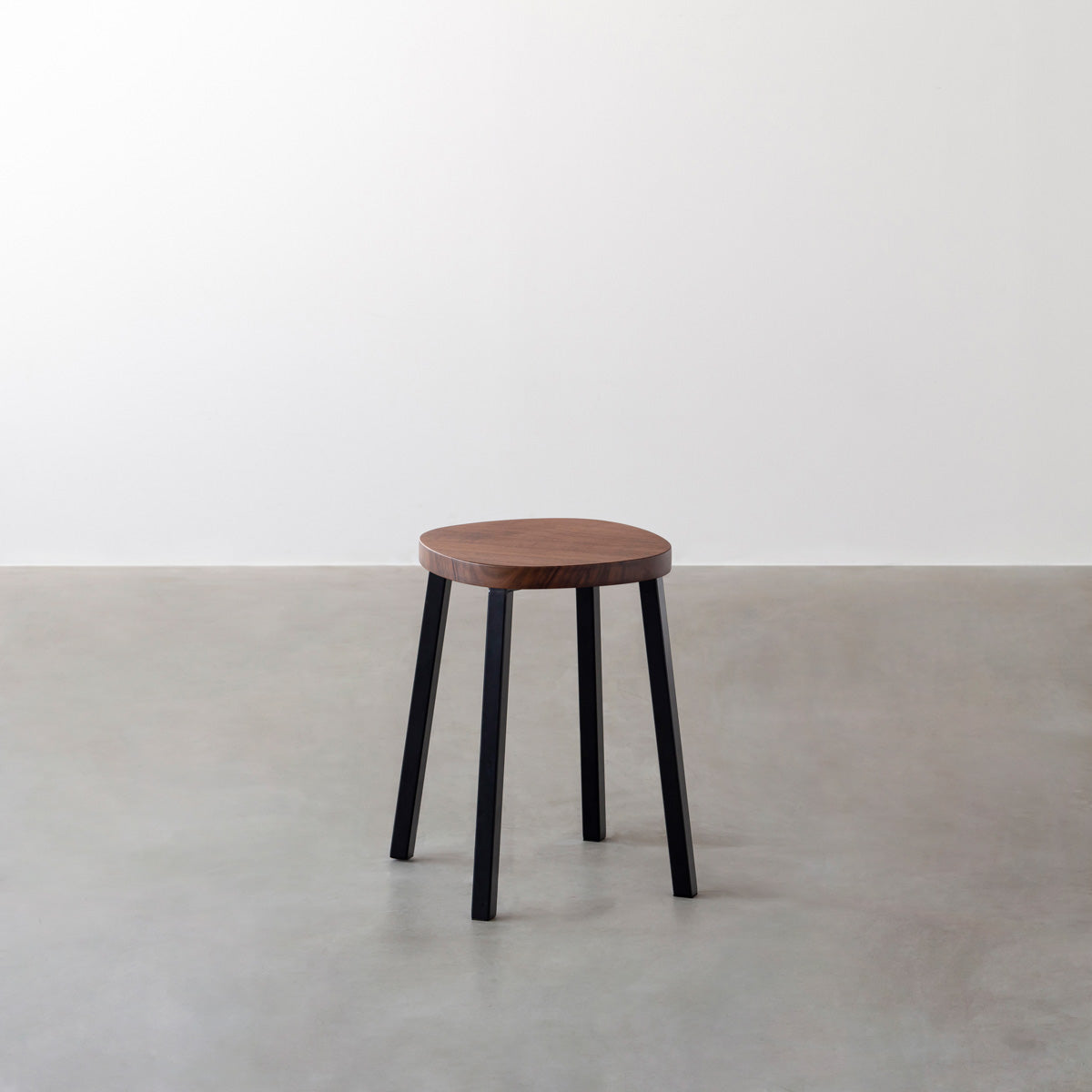 KANADEMONOの無垢ウォルナットSquircle座面とブラックのSlant Bar脚を合わせたシンプルモダンなスツール