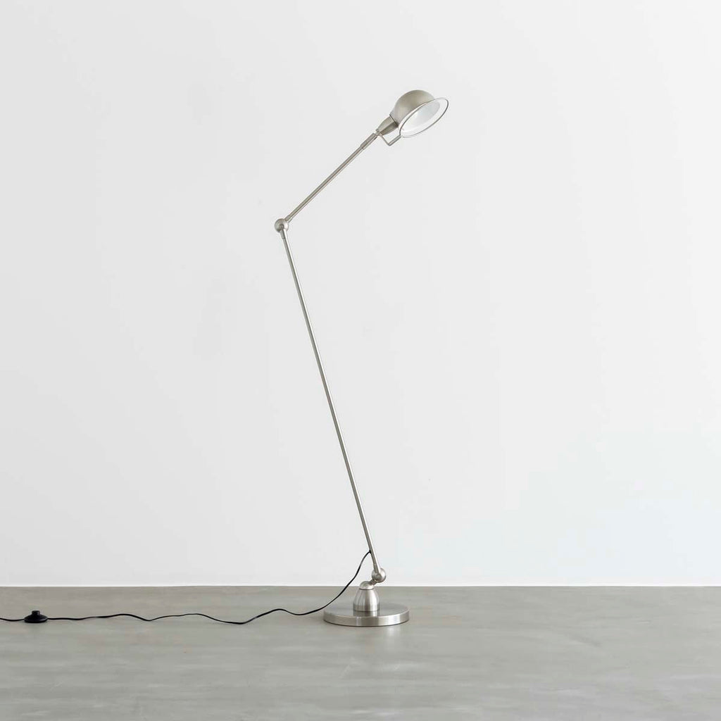 丸みのあるシェードとシャープなシルエットが特徴的なシルバーのフロアランプ