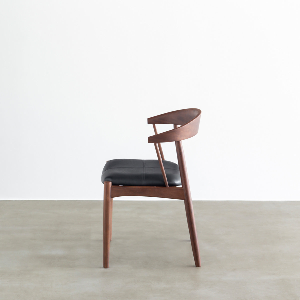 ウォルナット材を丸みのあるシルエットに仕上げた北欧スタイルのダイニングチェア（側面）