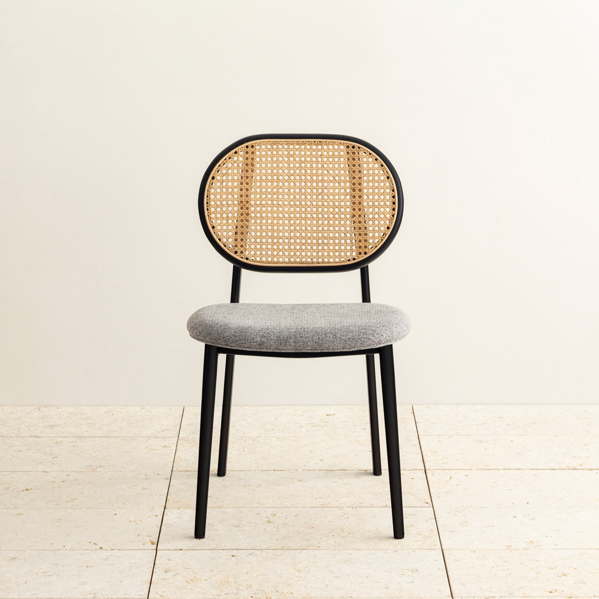 クラシカルなデザインの背もたれにダークグレーのファブリックと黒のスチール脚を組み合わせたレトロモダンなダイニングチェア（正面）