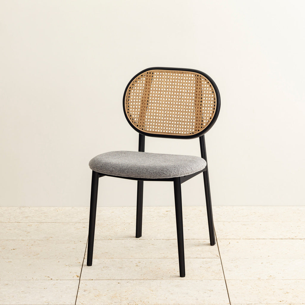 クラシカルなデザインの背もたれにダークグレーのファブリックと黒のスチール脚を組み合わせたレトロモダンなダイニングチェア（斜め向き）